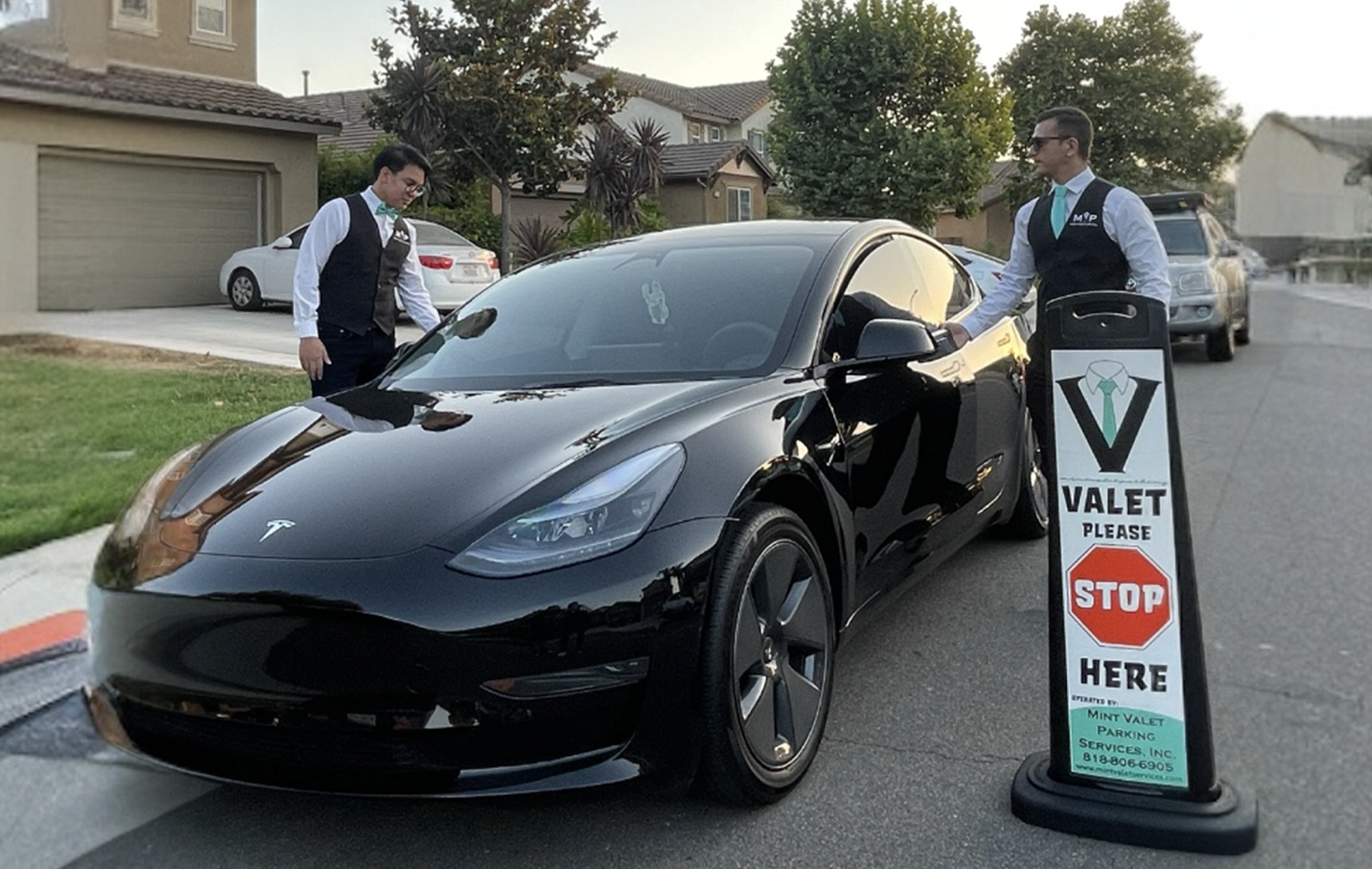 Mint Valet Parking Services attendants managing a Tesla, providing professional valet service in a residential area